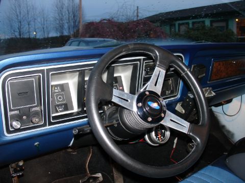 1978 Ford Bronco - The interior of a 1978 Ford Bronco features a blue dashboard, an aftermarket steering wheel, and various gauges.