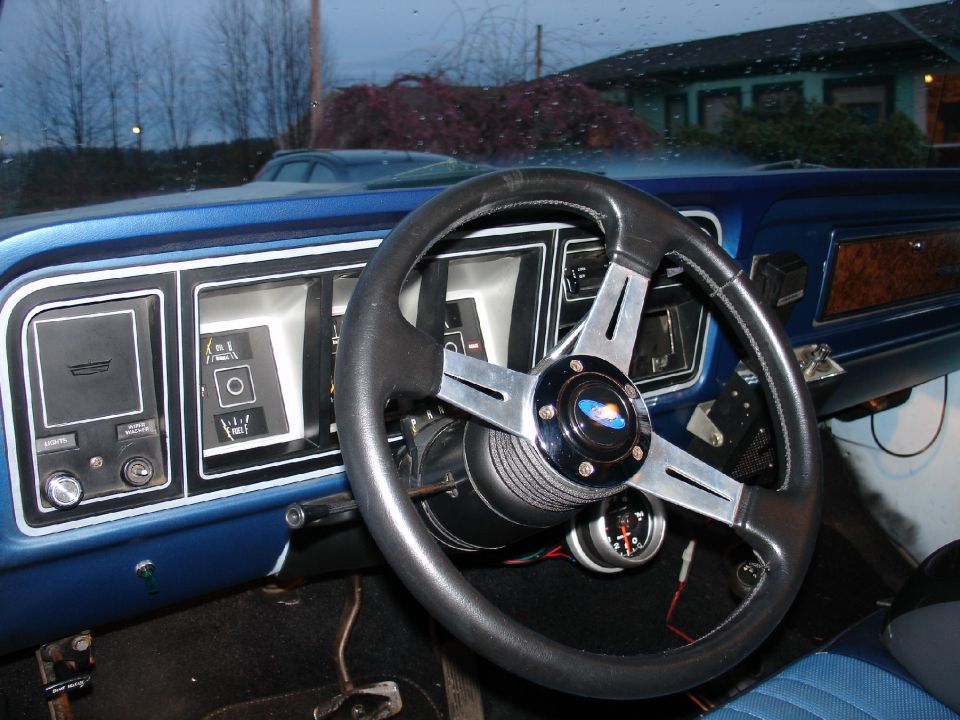1978 Ford Bronco interior with blue dashboard, aftermarket steering wheel, and gauges