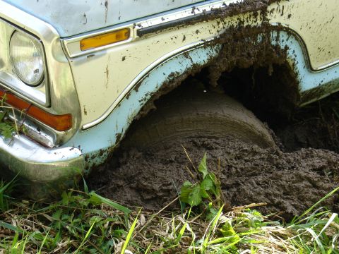1978 Ford Bronco - This truck is deeply embedded in mud, with the front wheel almost completely submerged.