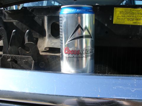 1978 Ford Bronco - A Coors Light can sits in the engine bay, obscuring the radiator support and hood latch mechanisms.
