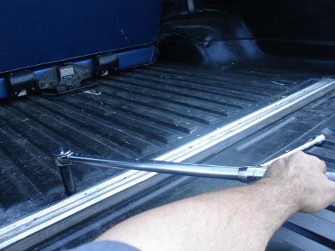 1978 Ford Bronco - A torque wrench is being used in the bed of a blue pickup truck.