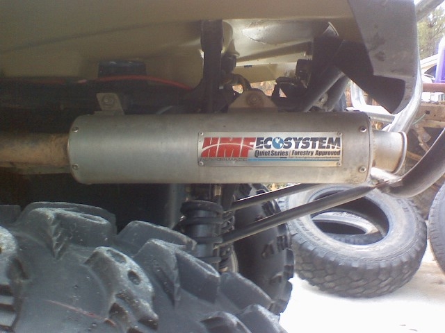 HMF EcoSystem slip-on muffler mounted under an ATV above knobby tires