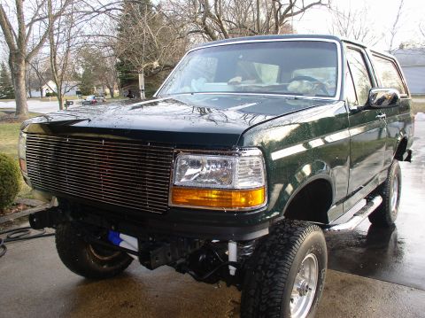 1993 Ford Bronco - This 1993 Ford Bronco features a prominent chrome grille and appears to have a lifted suspension.