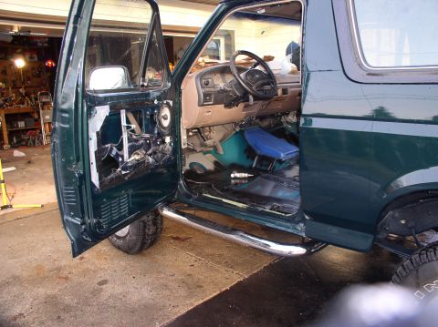1993 Ford Bronco - Interior view of a 1993 Ford Bronco with the driver's door open and the door panel removed for work.