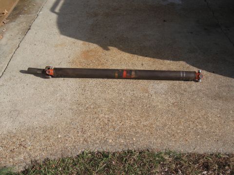 1968 Shelby GT500 - A driveshaft with orange and red markings is shown lying on a concrete surface.