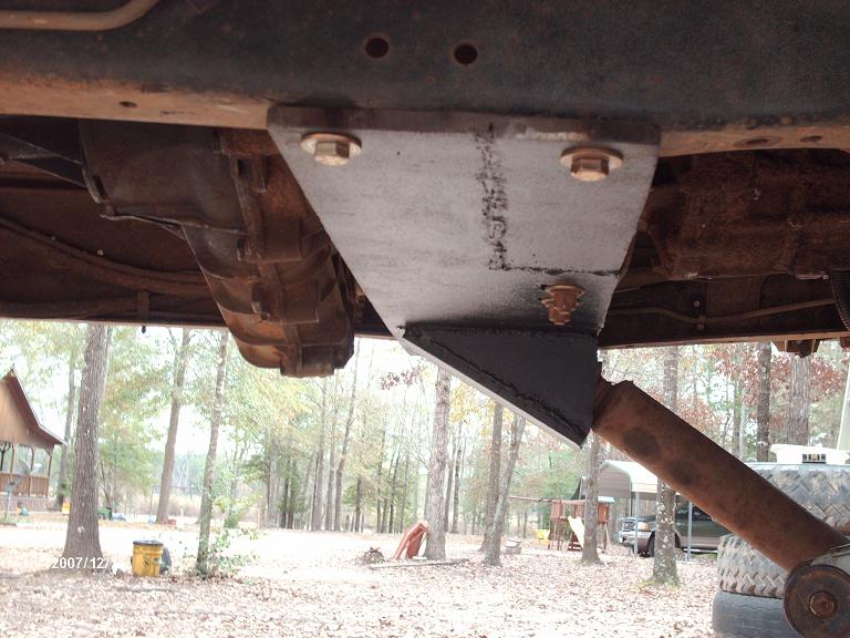 Custom suspension bracket attached to truck frame near transmission