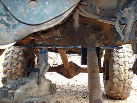 1990 Ford F-150 - Vehicle undercarriage with transmission and rear axle visible, supported by a floor jack.