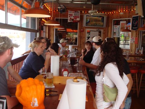1992 Ford Bronco - A group of people are gathered at a bar, with drinks and food items visible on the counter.