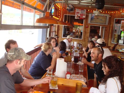 1992 Ford Bronco - A group of friends enjoy drinks and conversation at a lively bar with an open-air feel.