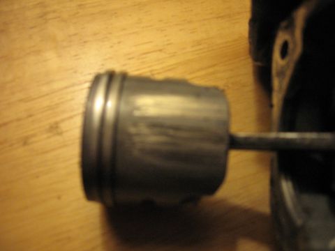 1992 Ford Crown Victoria - This is a piston, likely from an engine, shown on a wooden table.