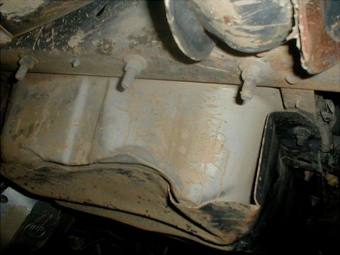 1996 Ford Bronco - Close-up of the underbody, showing suspension parts and frame structure obscured by dirt.