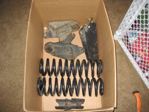 1981 Ford Bronco - Several vehicle suspension components are neatly arranged inside a cardboard box.