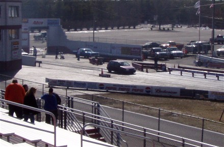 1999 Ford Crown Victoria - A drag strip event is underway with multiple vehicles visible on the track and in the background.