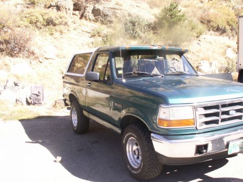 1986 Ford Bronco - This Ford Bronco has a white roof and is parked outdoors.