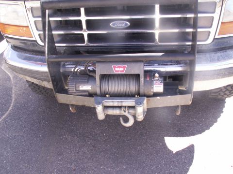 1986 Ford Bronco - Front view of a Ford truck equipped with a WARN winch and brush guard, likely a 1992 model based on grille design.