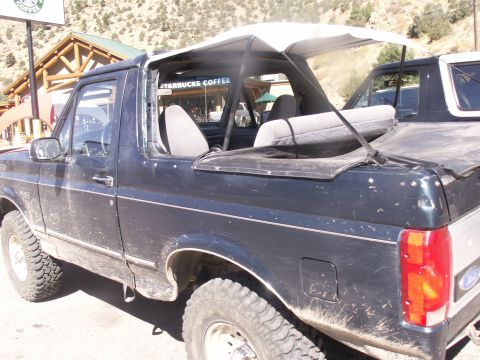 1986 Ford Bronco - A Ford Bronco is parked outside a Starbucks with mountains in the background.