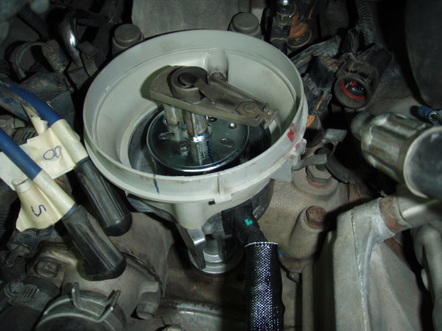 Close-up of a vehicle's distributor cap with spark plug wires labeled '8' and '5'