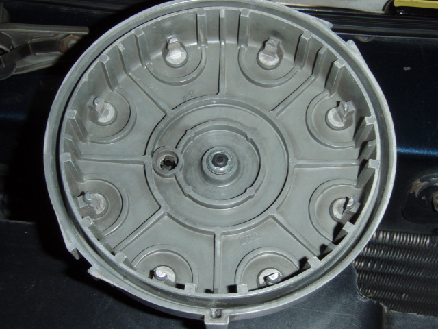 Inside of an automotive distributor cap showing eight terminal towers