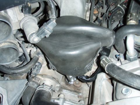1995 Ford F-150 - Close-up view of engine parts, focusing on a black plastic component and various hoses.