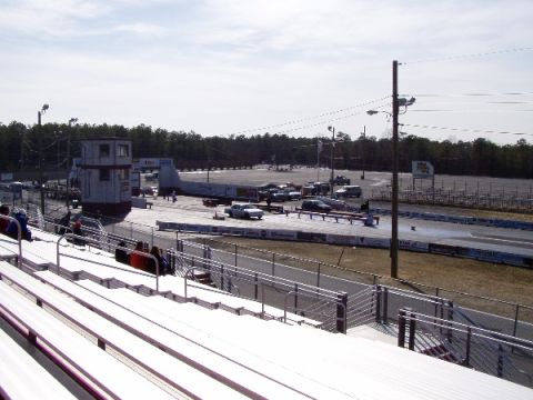 1999 Ford Crown Victoria - A drag strip scene with bleachers and multiple vehicles visible.