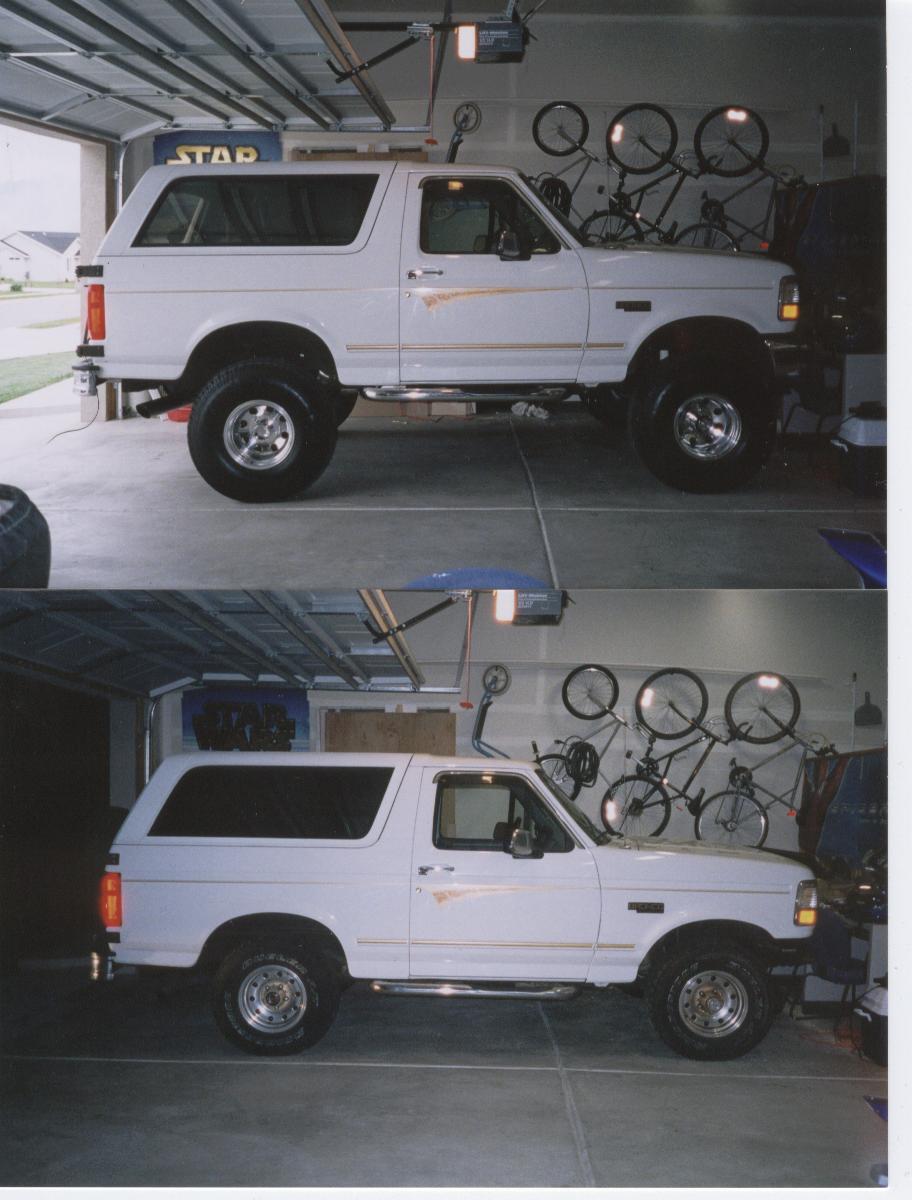 White two-door Ford Bronco SUV parked in a garage, side view.