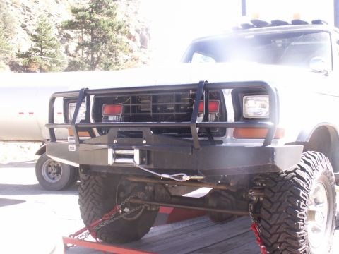 1986 Ford Bronco - Frontal view of a white truck, likely from the 1980s, equipped with a heavy-duty bull bar and winch.