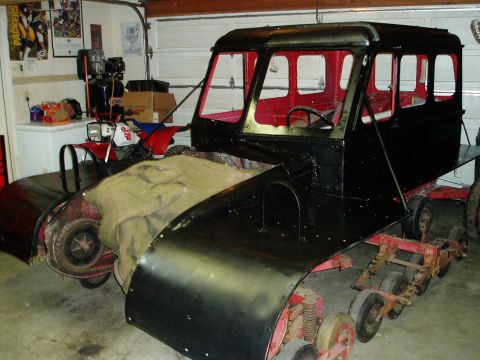 2000 Ford E350 - This custom snow vehicle is in a garage, with a red ATV and posters on the wall.