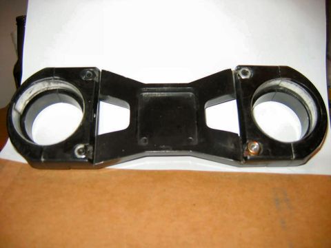 1985 Ford LTD Crown Victoria - This is a black motorcycle triple tree clamp with two large circular openings for forks.