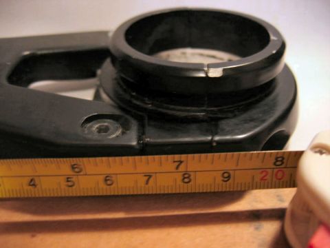 1985 Ford LTD Crown Victoria - A black plastic component is shown with a yellow measuring tape indicating its dimensions, suggesting it is a vehicle part.