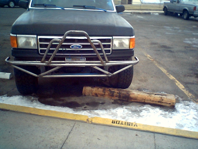 1990 Ford Bronco front end with custom metal bumper, log on ground