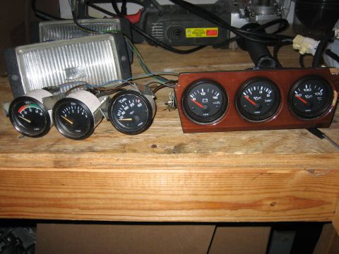 1987 Volkswagen Scirocco - A collection of automotive gauges and headlights are laid out on a wooden surface, likely for repair or installation.