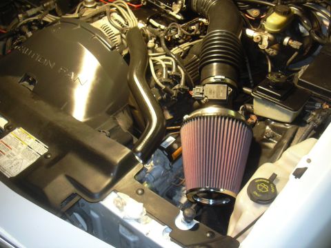 1997 Ford Crown Victoria - Close-up of a car's engine bay, showing an aftermarket air intake system.