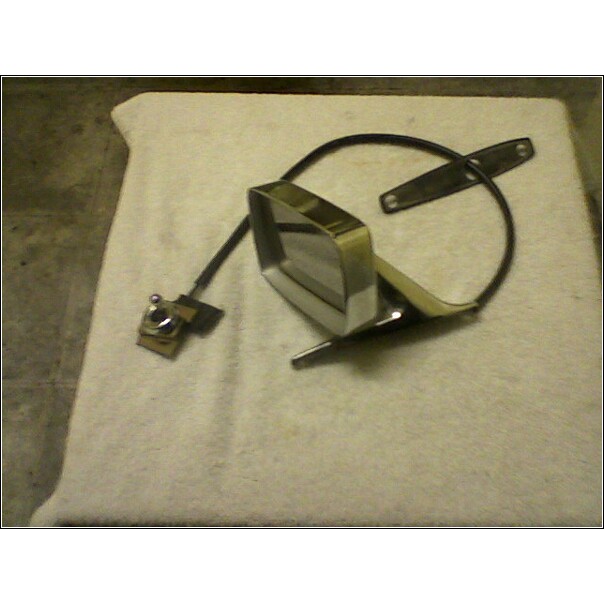 Car side mirror assembly with chrome trim and black backing, resting on a white cloth