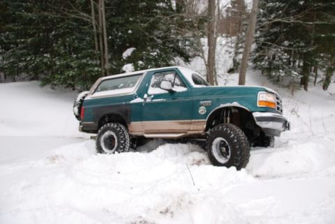 1996 Ford Bronco - This 1996 Ford Bronco is stuck in deep snow, showing its lifted suspension and off-road tires.