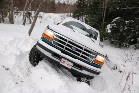 1996 Ford Bronco - A 1996 Ford Bronco navigates deep snow, showing its front 3/4 view as it gets stuck.