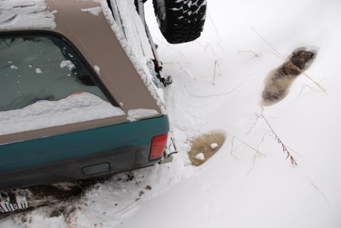 1996 Ford Bronco - Snow covers the rear of a 1996 Ford Bronco, with a spare tire mounted externally.