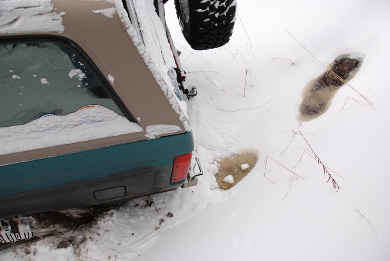 1996 Ford Bronco rear in snow, spare tire visible on back