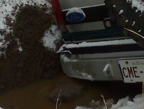 1996 Ford Bronco - This 1996 Ford Bronco's rear is stuck in mud and snow, with its Brunswick license plate visible.