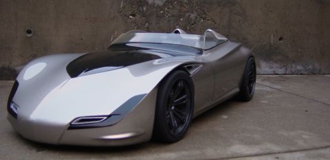 1993 Ford Probe - A futuristic silver concept car with a unique design is parked outdoors.