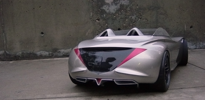 Silver convertible sports car rear view with triangular pink accents and dual exhaust