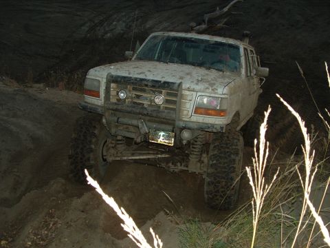 1992 Ford F-350 - A white 1992 Ford F-350 truck navigates a muddy off-road course.