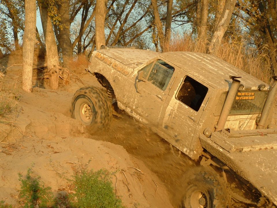 1992 Ford F-350 climbing a muddy hill with large tires