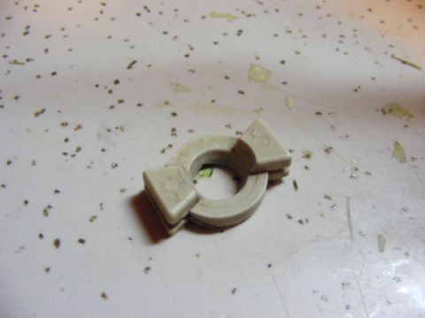 1993 Ford Bronco - A beige plastic part with two triangular protrusions is shown against a speckled surface.