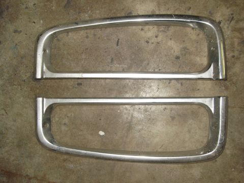 2007 Ford Bronco - Two chrome headlight bezels are shown against a concrete background. These appear to be replacement parts.