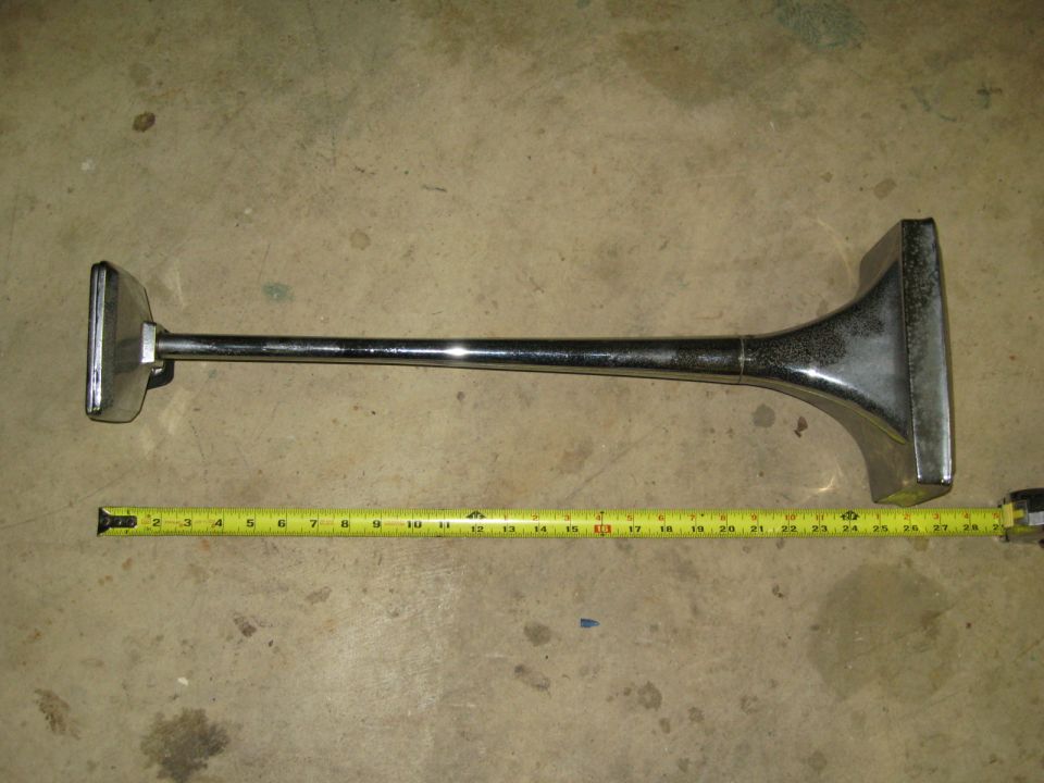 Chrome horn and yellow measuring tape on concrete floor