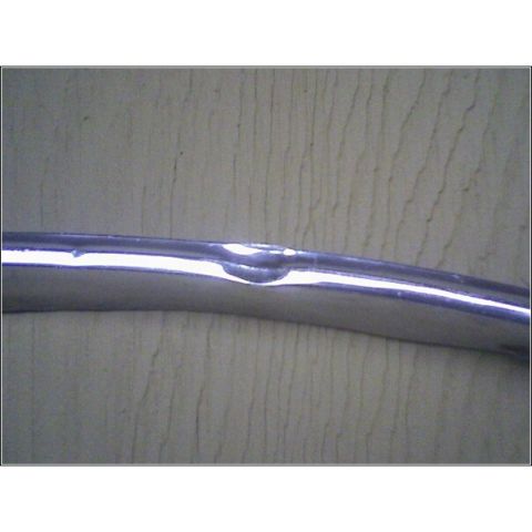 1972 Ford Ranchero - A close-up view of a damaged chrome trim piece, likely from a vehicle part.