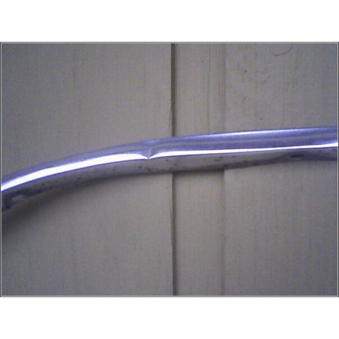 1972 Ford Ranchero - A close-up view of a damaged chrome trim piece, possibly from a vehicle, against a neutral background.