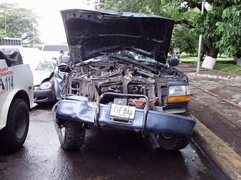 1995 Ford F-150 - A severely damaged 1995 Ford F-150 sits with its hood up, indicating the aftermath of a significant collision.
