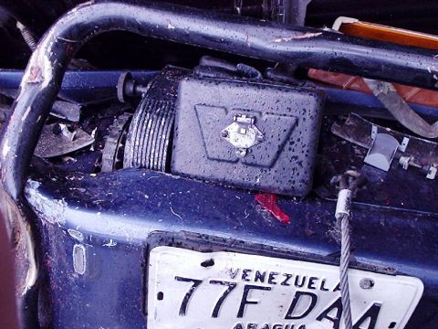 1995 Ford F-150 - The rear of a damaged vehicle shows a trailer hitch assembly and a Venezuelan license plate.