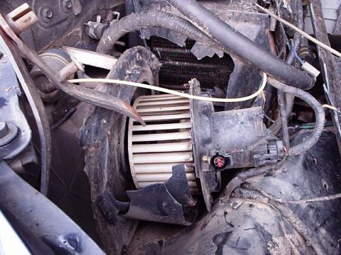 1995 Ford F-150 - Close-up view of a blower motor and a damaged radiator, likely from an engine bay.